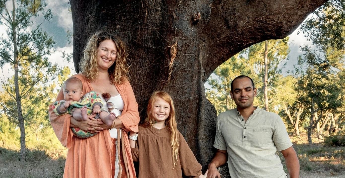The family together in the forest in front of a large tree