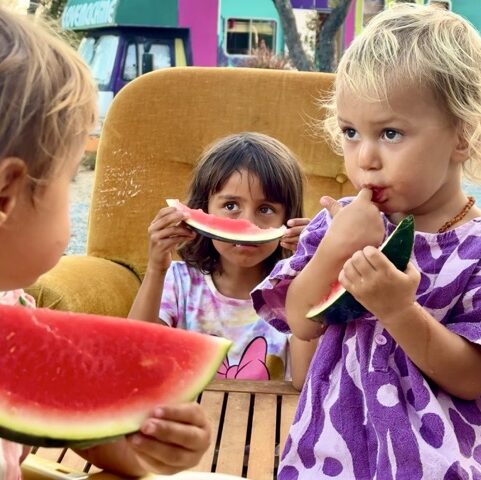 Children at Vila Akoya go camping in Tiny House Village eating fruit